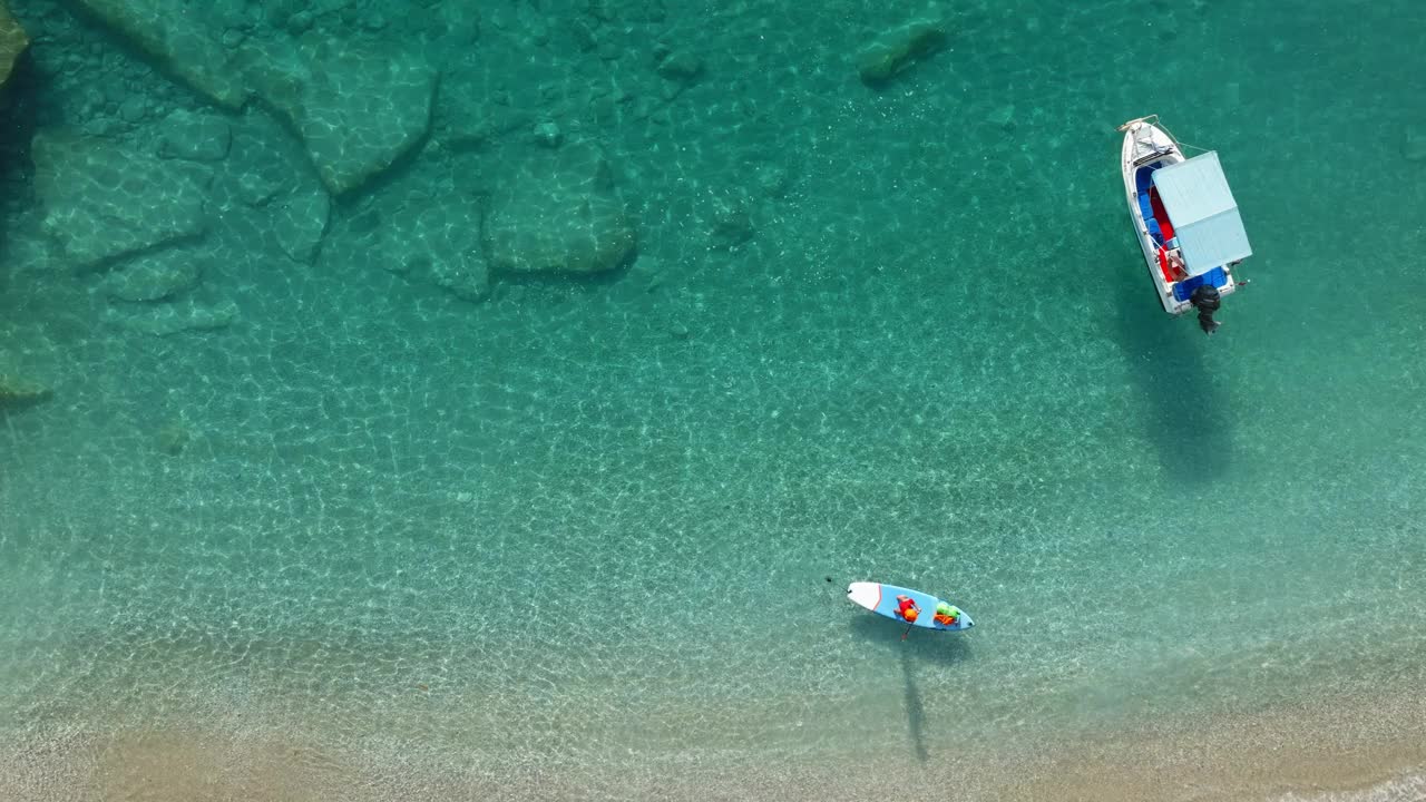 锚定的船和人站在站立桨板上从无人机的海景。地中海风景。视频素材