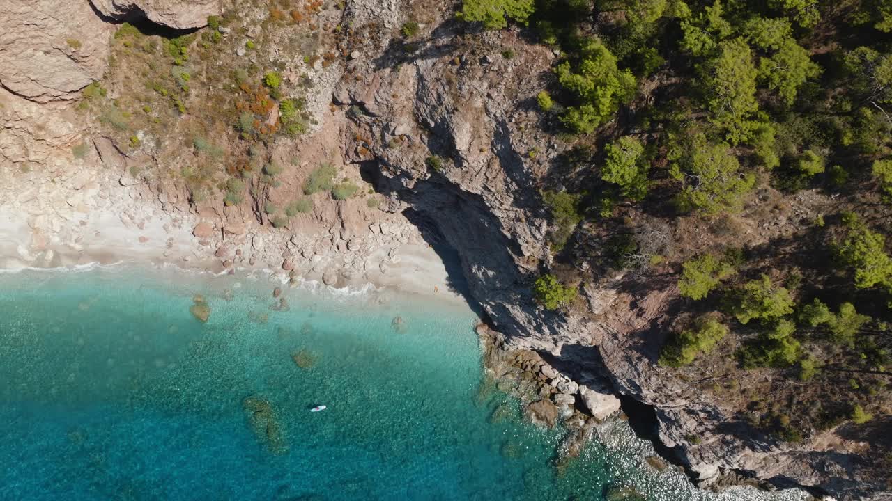 男子在站立式桨板上游泳，俯瞰海景。视频素材