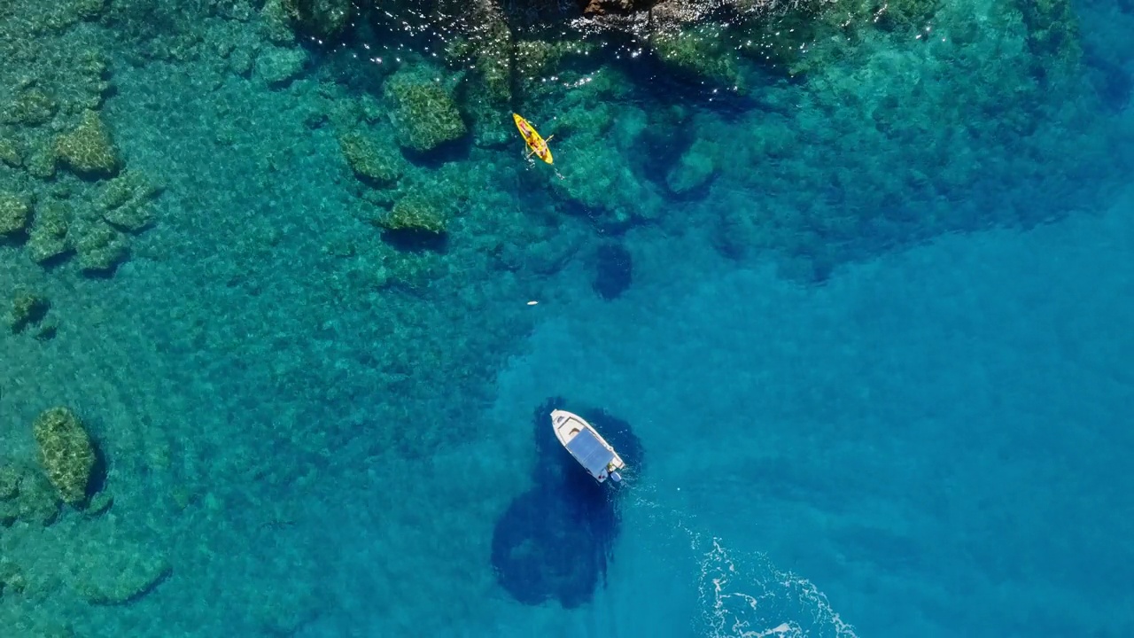 锚定的船和男人和女人划着皮划艇从无人机的海景。地中海风景。视频素材