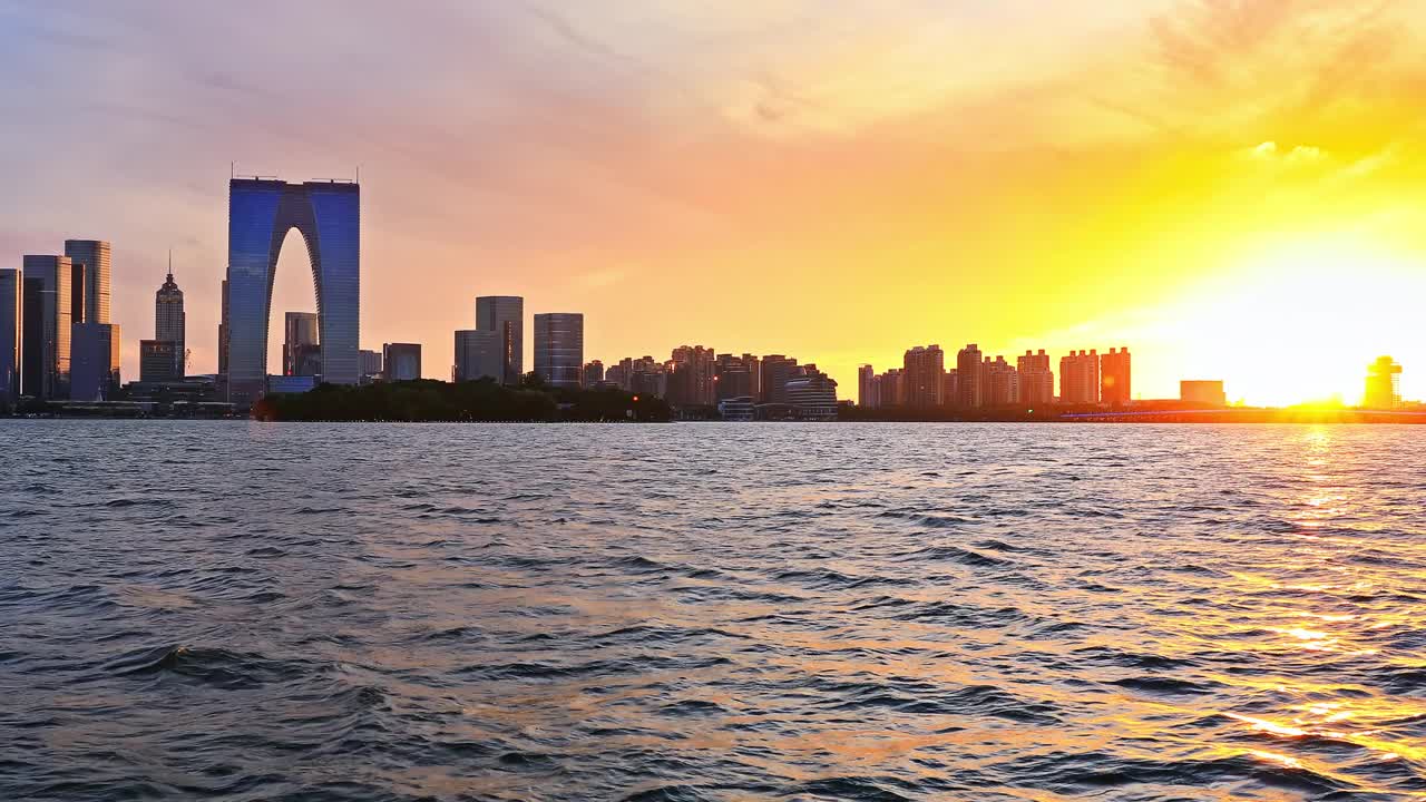 苏州的天际线和现代建筑在日落湖畔的风景，江苏省，中国。视频素材