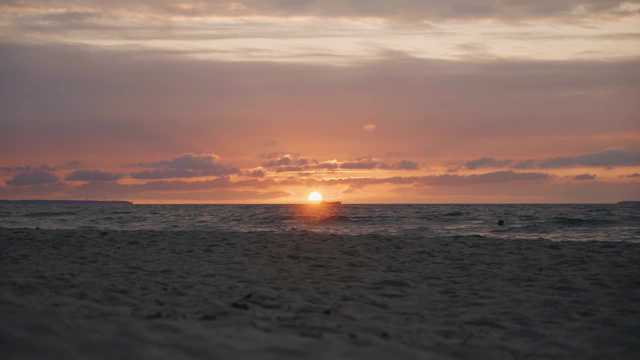 海上的太阳从地平线上落下，一艘船驶过。晚上在海边拍的照片很酷视频素材