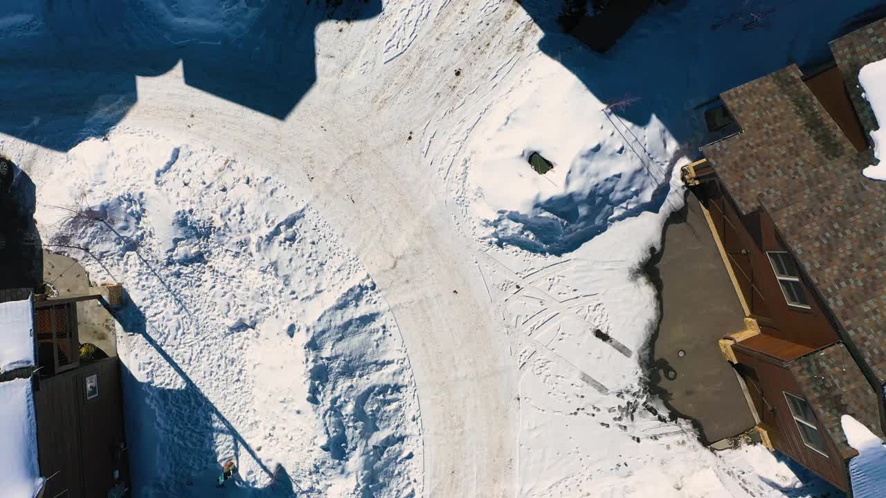 冬季邻里房屋覆盖在松树林中的雪，在布雷肯里奇科罗拉多山城死胡同的无人机俯瞰与乡村度假屋，空中鸟瞰视频素材