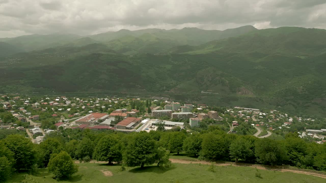 这座城市的房屋被树木繁茂的高山和悬崖所环绕。无人机视频视频下载