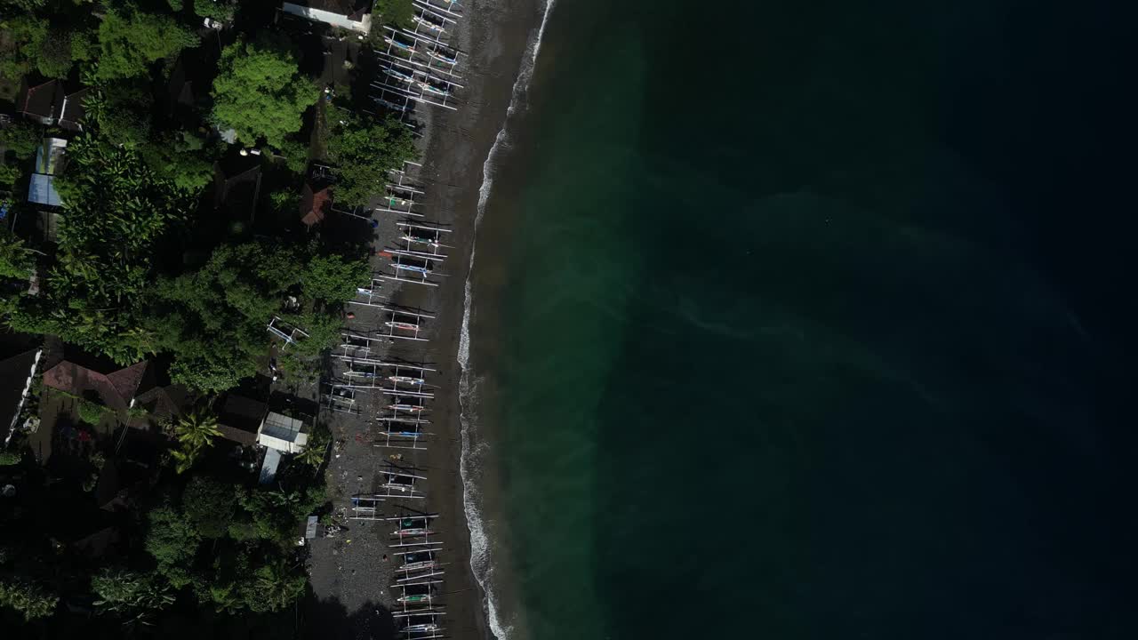 鸟瞰沿着海岸线的船只在美丽的海滩上的阿米德，巴厘岛。天线。视频素材