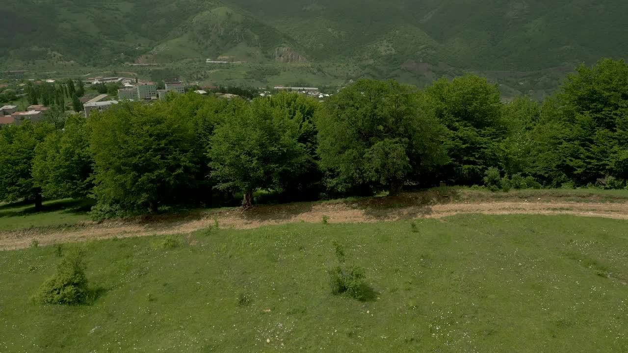 这座城市的房屋被树木繁茂的高山和悬崖所环绕。无人机视频视频下载