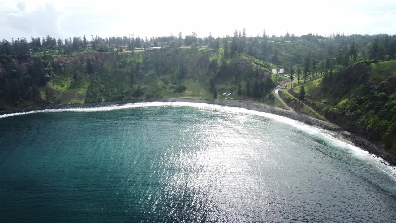 鸟瞰诺福克岛风景如画的风景，蓝绿色的海水和泡沫的波浪在岩石悬崖和森林和灌木丛的植被上破碎视频素材