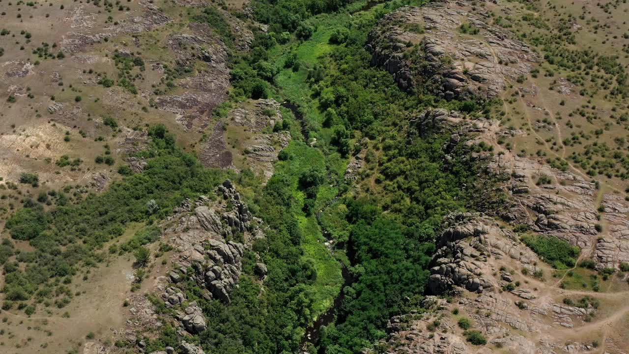 鸟瞰梅特沃沃德河的阿克托夫斯基峡谷，乌克兰尼古拉耶夫地区。夏日阳光明媚的日子里，浅浅的河流在峡谷底部的绿色环境和悬崖上流淌视频素材