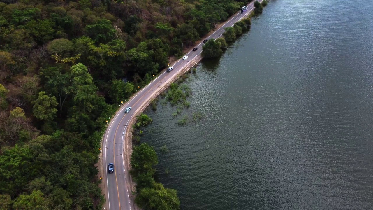 鸟瞰图的汽车行驶在道路之间的水和森林视频下载