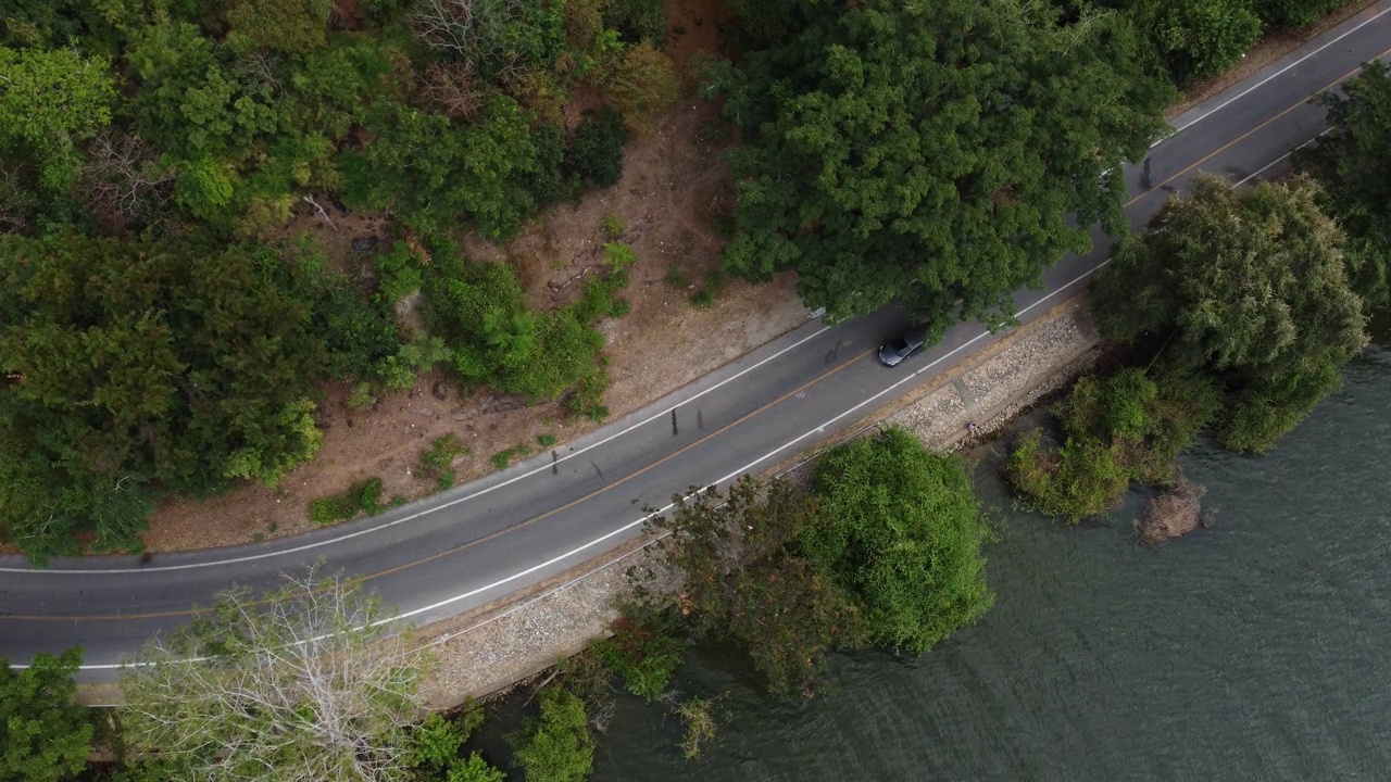 鸟瞰图的汽车行驶在道路之间的水和森林视频下载