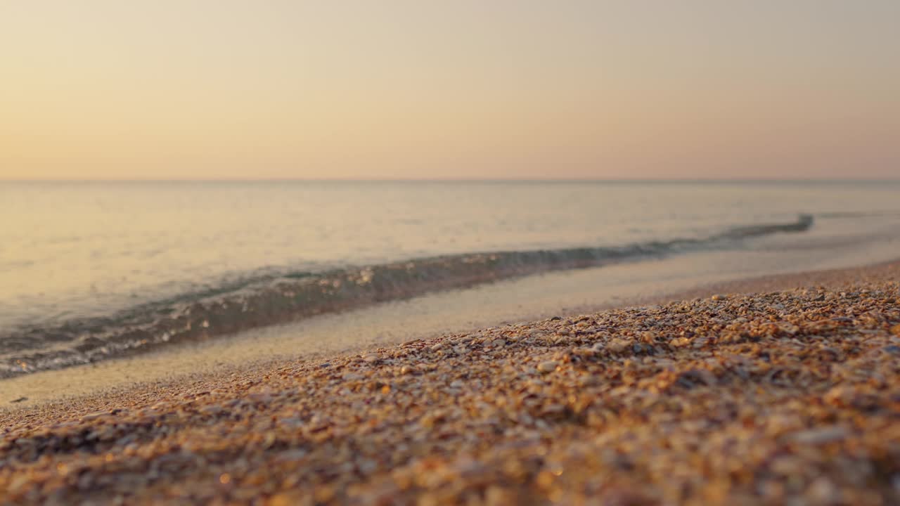 美丽的风景与明亮的金色波浪日落在海滩上的黑海。视频素材