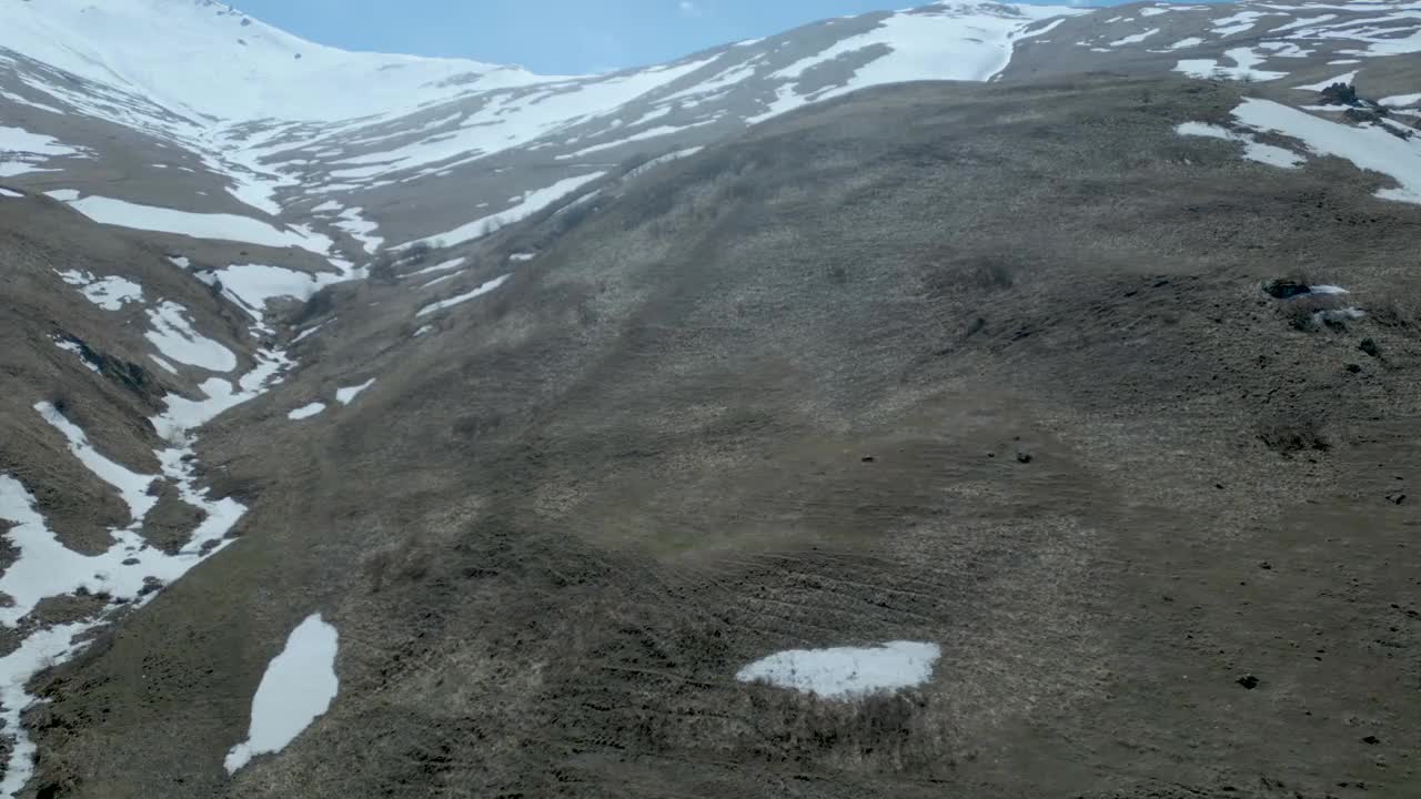 高空鸟瞰图，蓝天下覆盖着白雪的高山视频下载