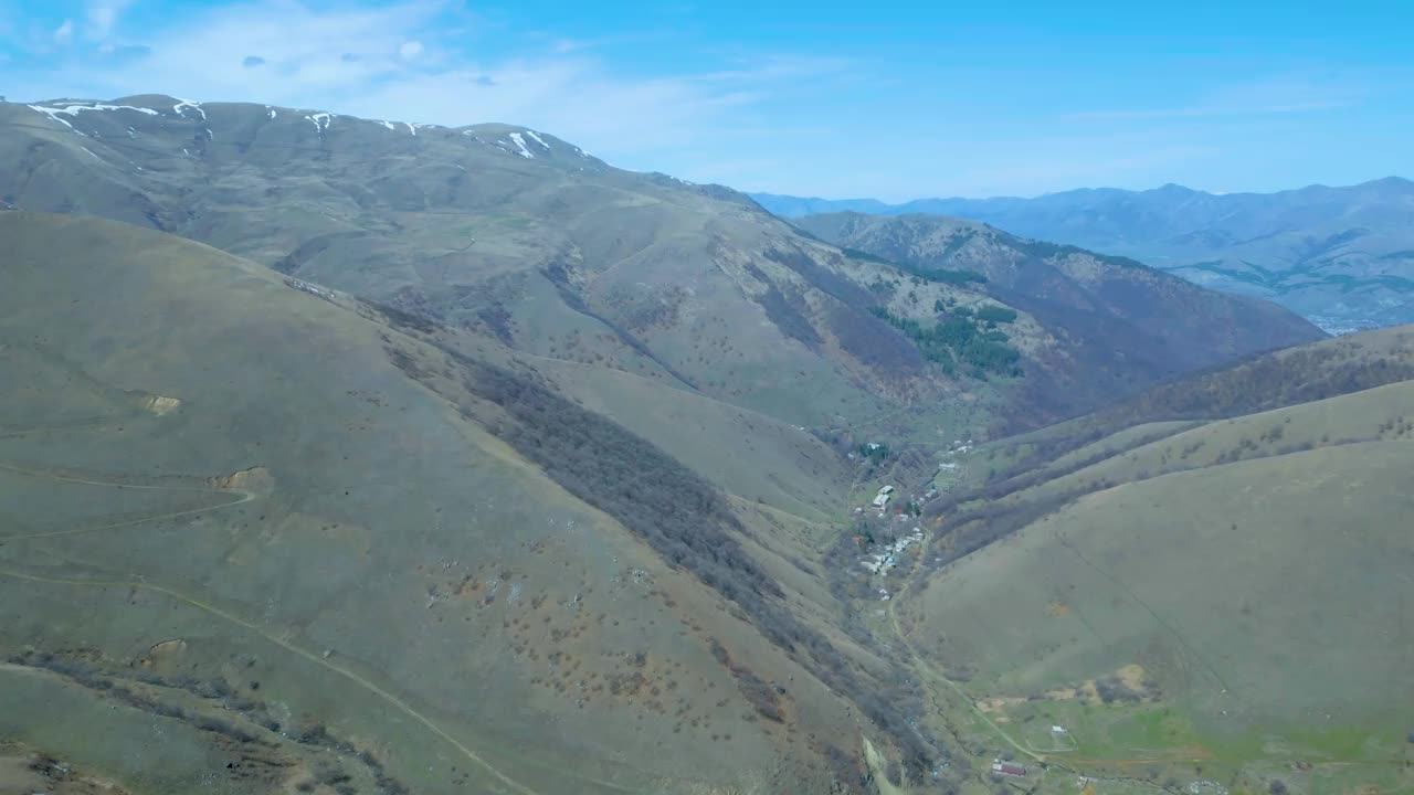 高空鸟瞰图，蓝天下覆盖着白雪的高山视频下载