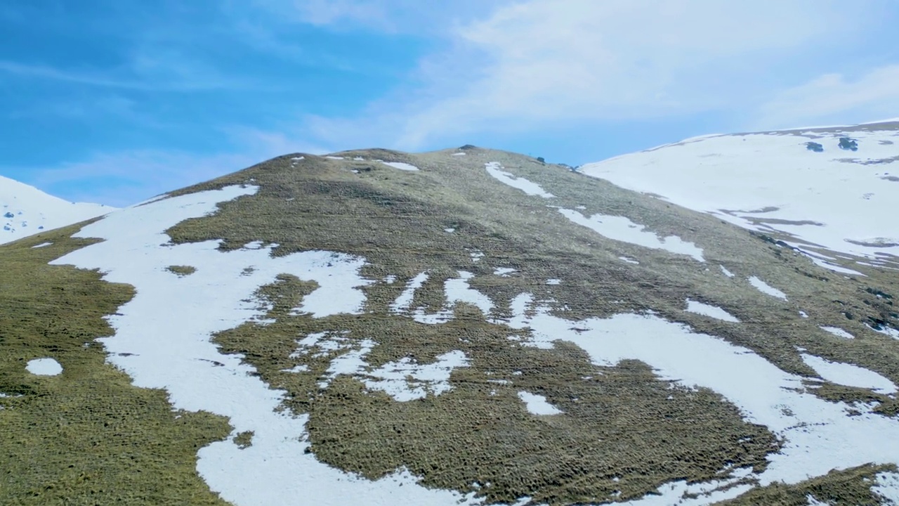 高空鸟瞰图，蓝天下覆盖着白雪的高山视频素材