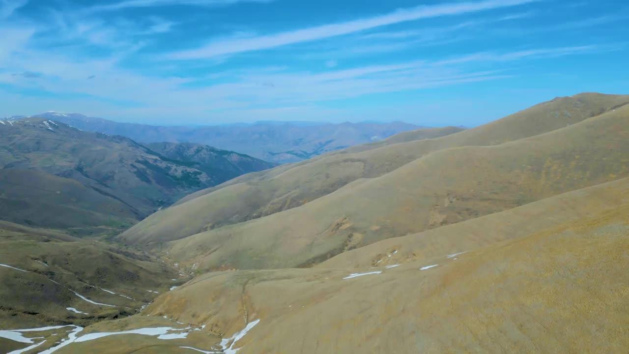 高空鸟瞰图，蓝天下覆盖着白雪的高山视频素材