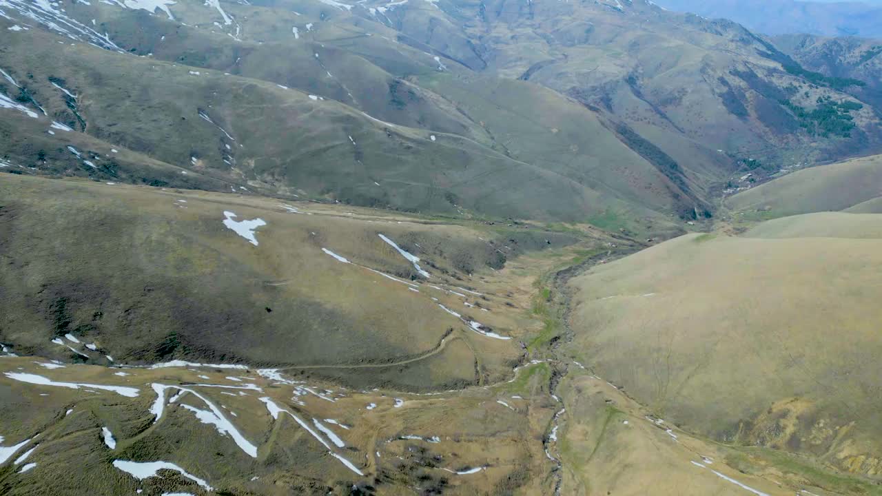 高空鸟瞰图，蓝天下覆盖着白雪的高山视频下载