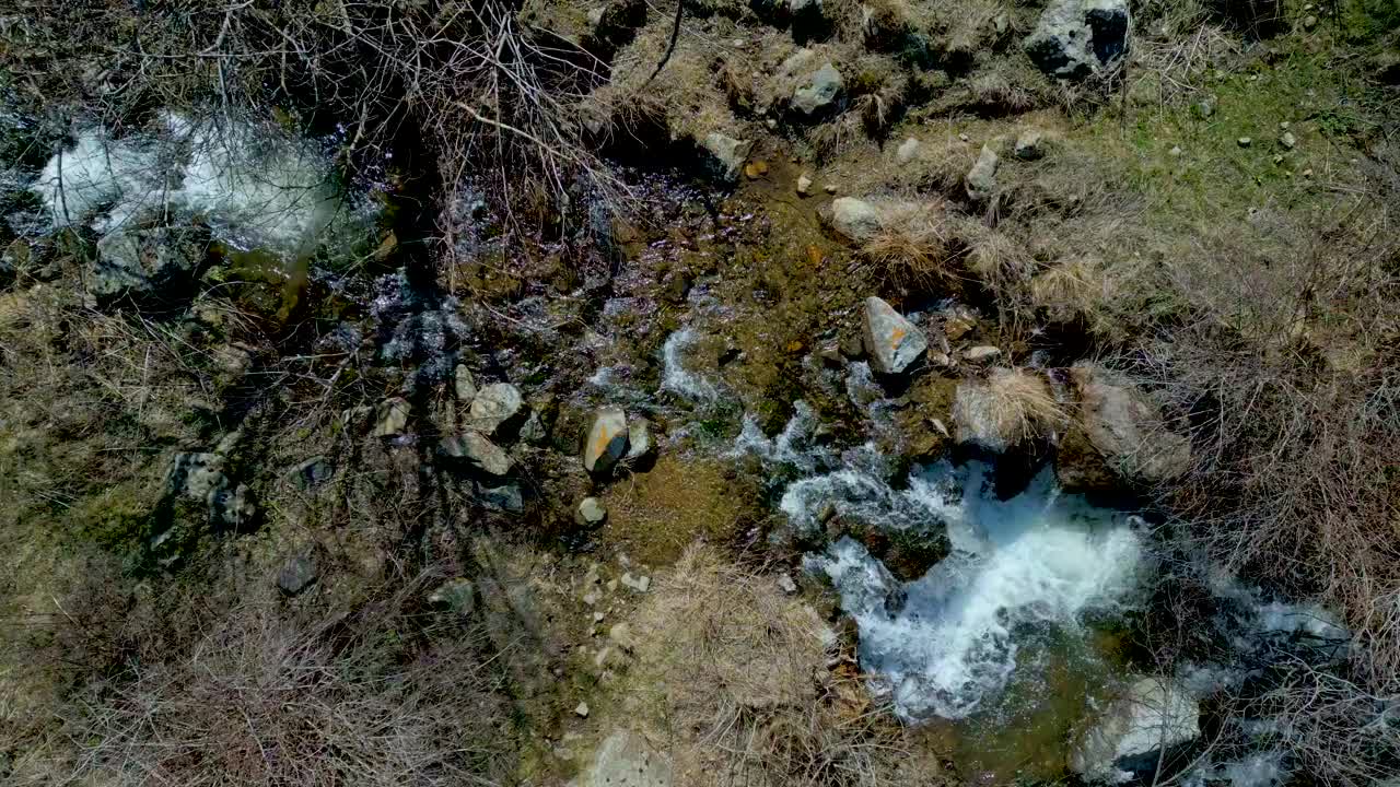 鸟瞰山间河流，岩石间奔流的小溪。视频下载