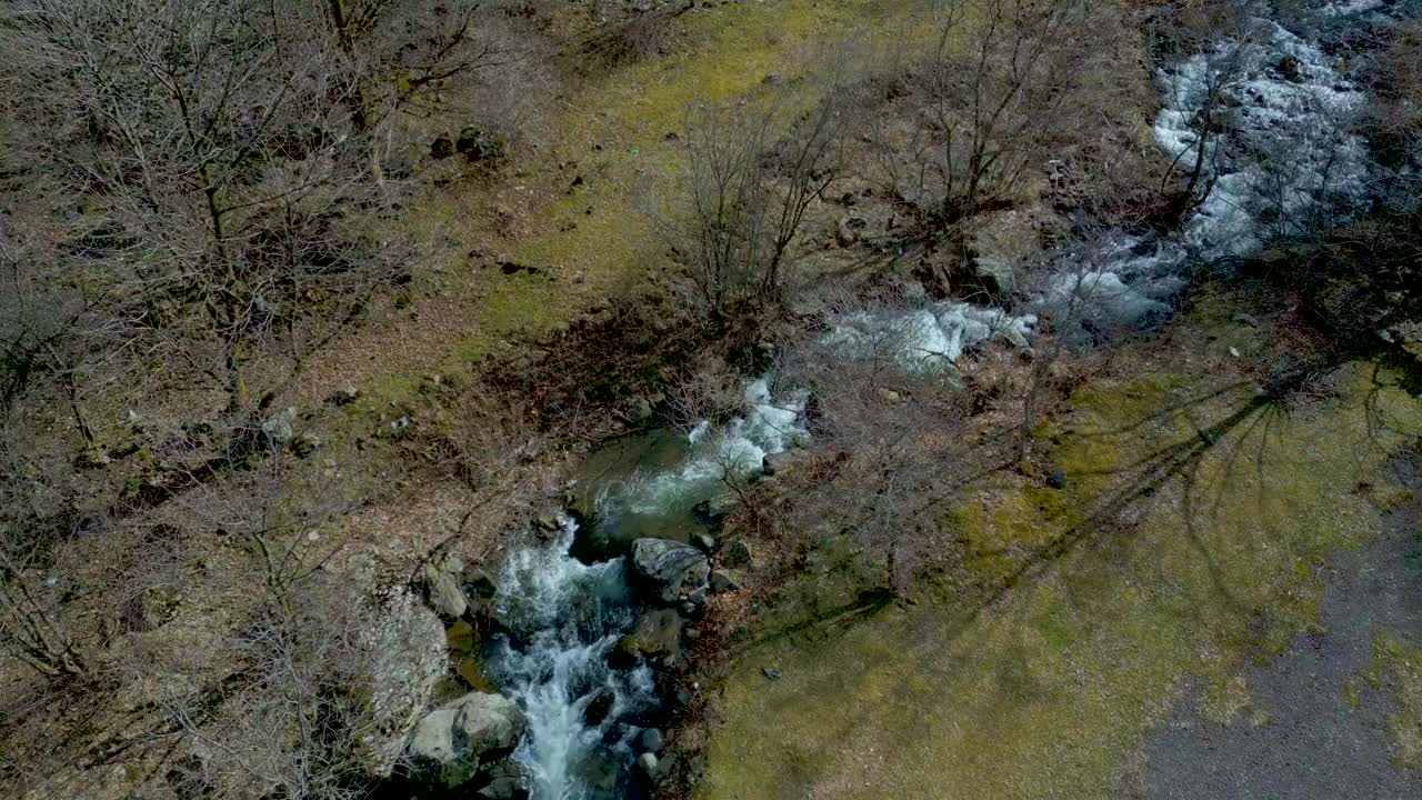 鸟瞰山间河流，岩石间奔流的小溪。视频素材