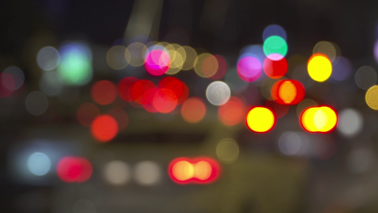 夜间城市道路交通灯光模糊散焦抽象散景。夜生活的背景视频下载