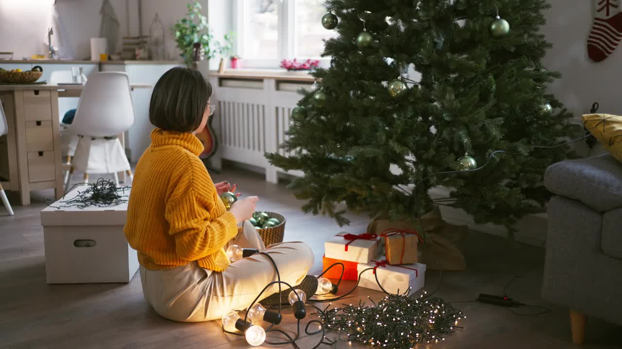 年轻的白人妇女正在装饰圣诞树视频素材