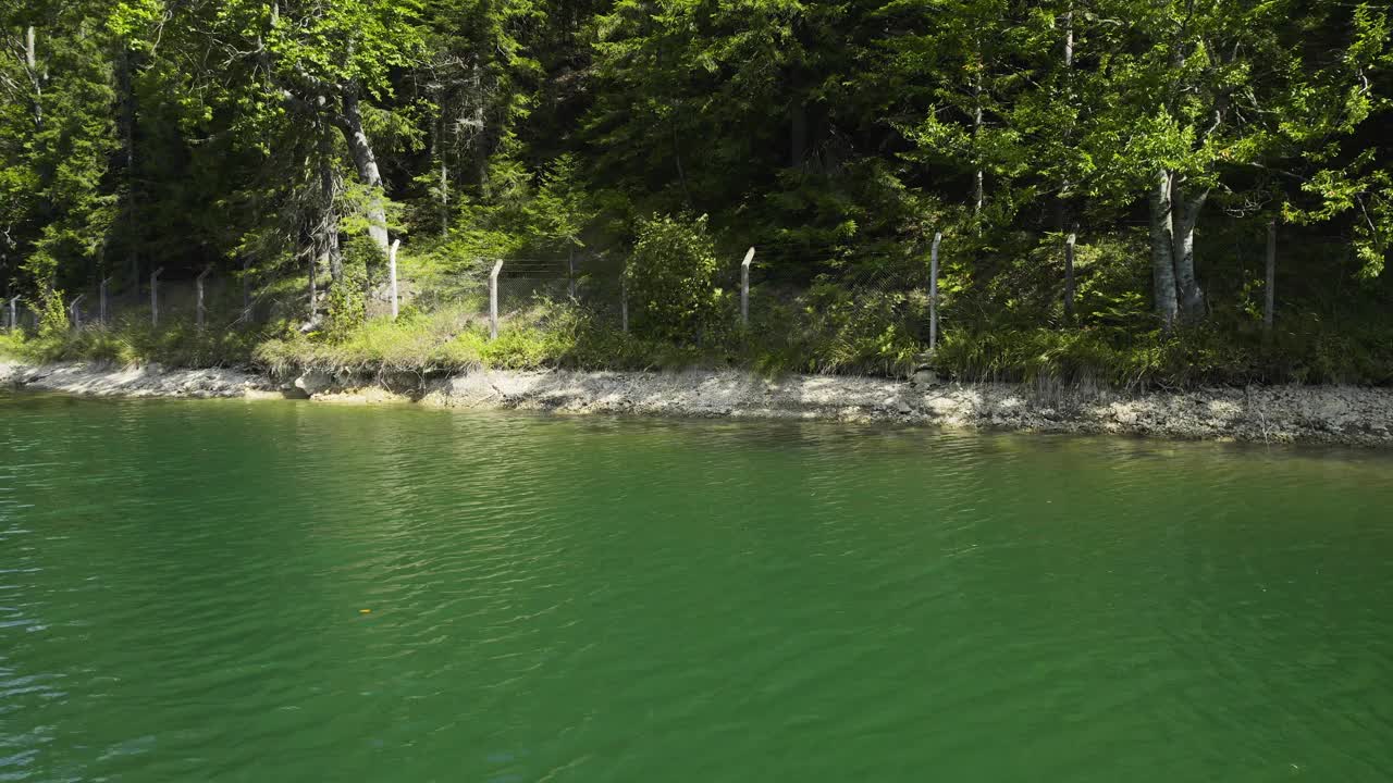 湖中水流的景象，岸边有栅栏，后面有树视频素材