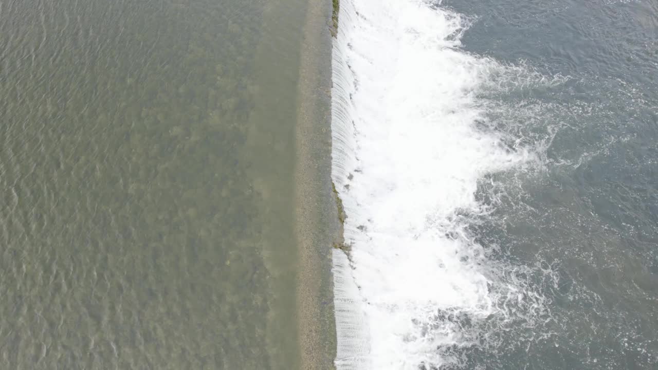 鸟瞰河堤与下游飞溅。视频素材