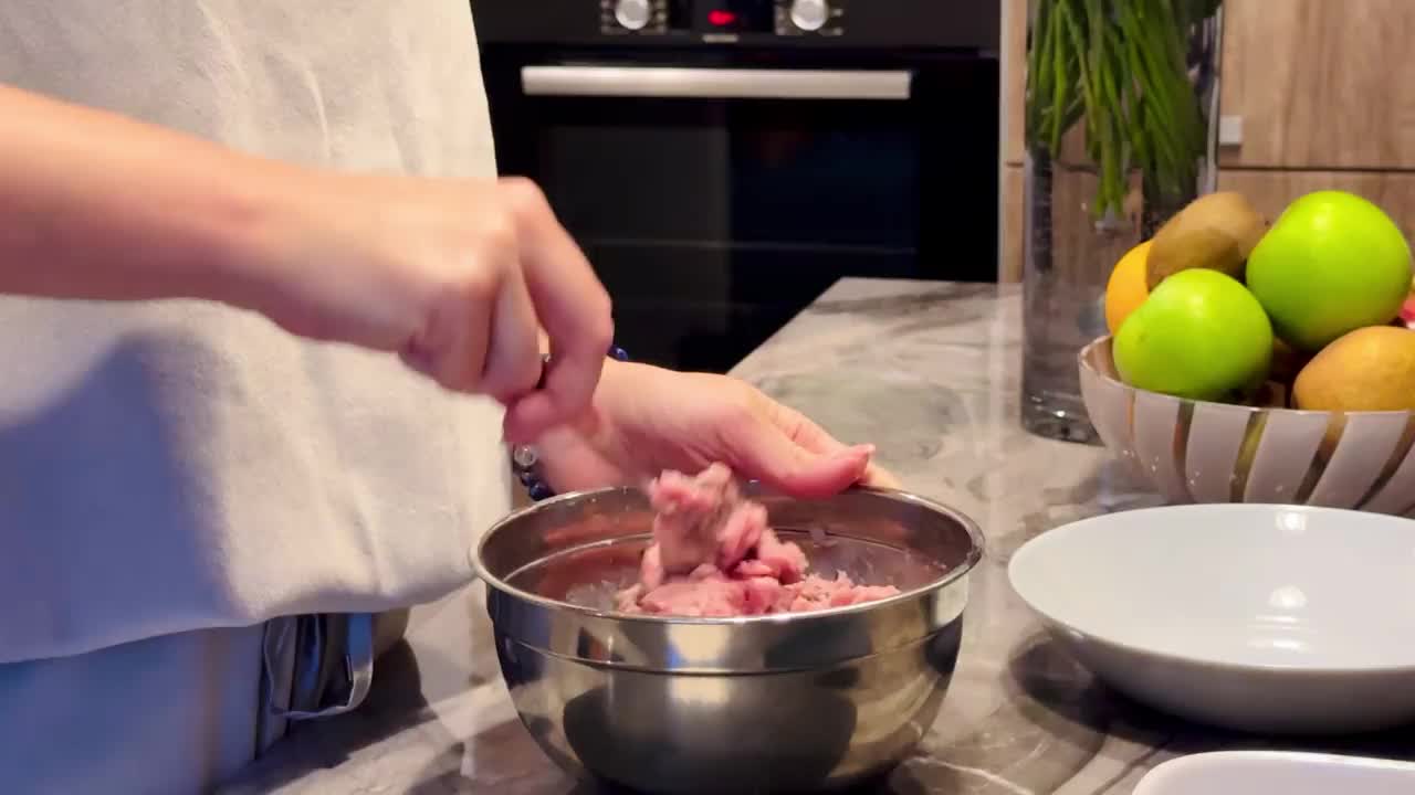 女孩把自制的肉末混合在一起做成肉排视频素材