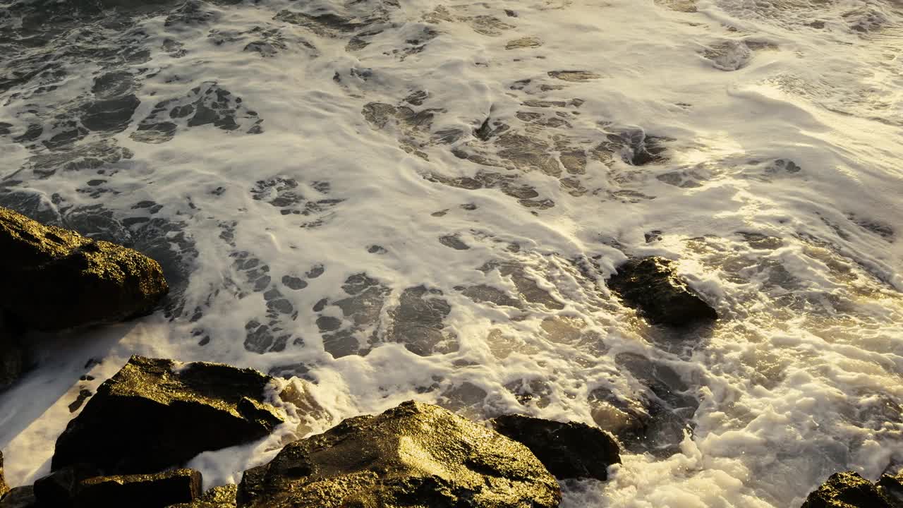 在地中海海岸的石头上冲浪。视频素材