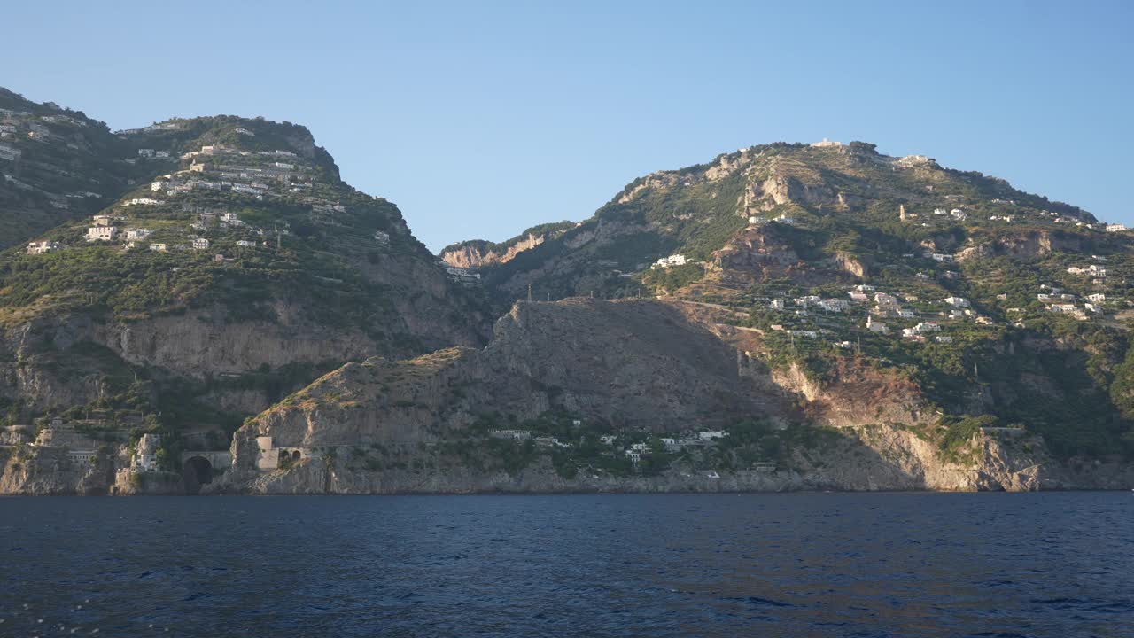 在阿马尔菲海岸的船上，从海上看福罗雷峡湾的美景。在晴朗的蓝天下，驶向意大利坎帕尼亚阿马尔菲海岸的渡轮。视频素材