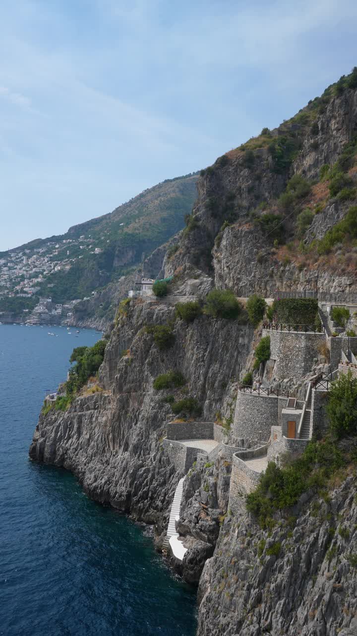 垂直俯瞰意大利阿马尔菲海岸，风景如画的普拉亚诺村，陡峭的悬崖上陡峭的石头楼梯，阳光明媚的日子里，美丽的海景视频素材