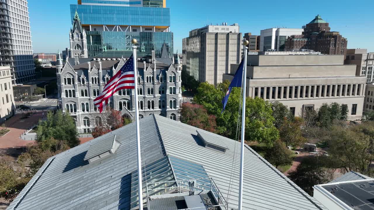 美国和弗吉尼亚州的国旗在弗吉尼亚州里士满市中心的国会大厦顶上飘扬。鸟瞰图。视频素材