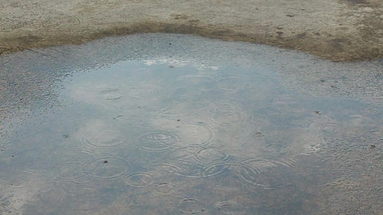 雨滴落在屋顶的水坑上。视频素材