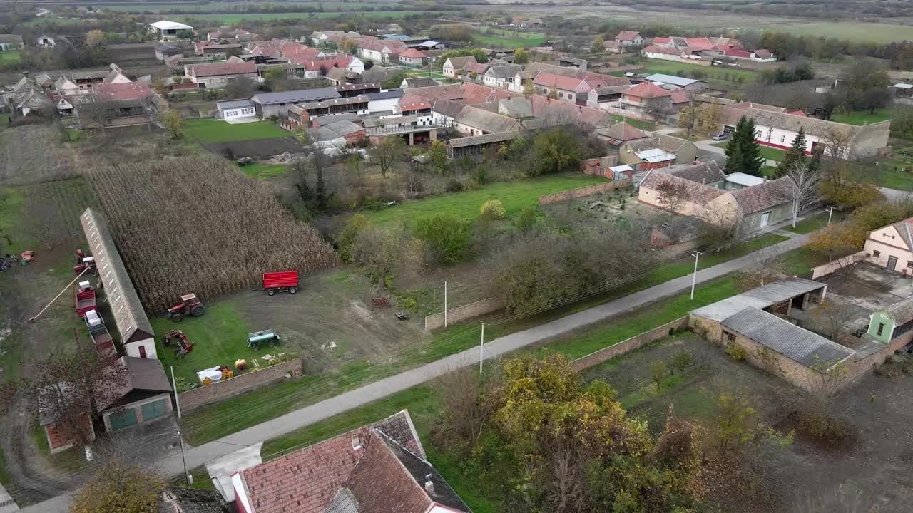 一架无人机在塞尔维亚弗尔萨克附近的Ritisevo村的农舍和田地上空飞行视频素材