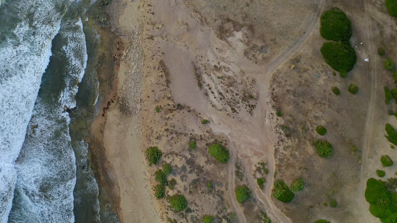 空中无人机俯瞰佛得角海岸，海浪冲击着意大利撒丁岛的狂野海滩视频素材