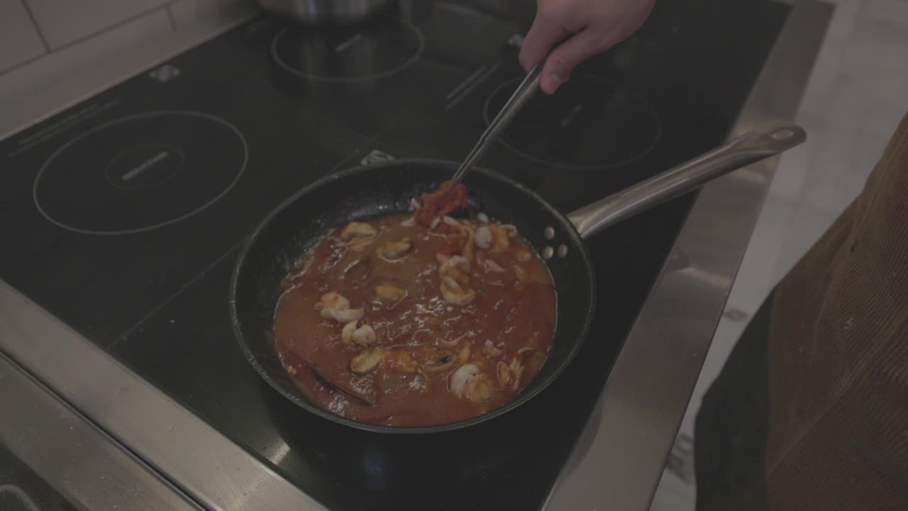 意大利面食烹饪过程。煮熟的意大利面与酱汁和配料混合在热锅里。意大利菜，传统食谱。慢动作120fps, ProRes 422, 10位，未分级的C-LOG视频视频素材