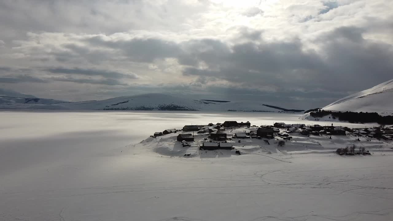 发现冰冻的Tabatskuri村，Samtskhe-Javakheti地区。雄伟的4K鸟瞰图，格鲁吉亚最大的高山湖泊，体积覆盖在雪中。巴库里亚尼附近的田园诗般的度假胜地视频素材