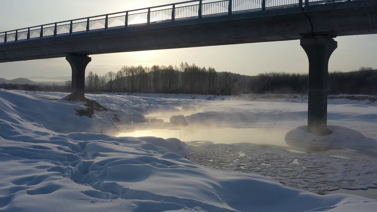 高角度鸟瞰图，白雪覆盖的河流和清晨的雾视频下载