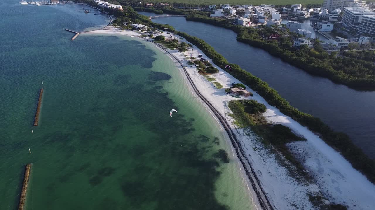 空中无人机观看坎昆港海滩与风筝冲浪在清澈的蓝色海水视频素材