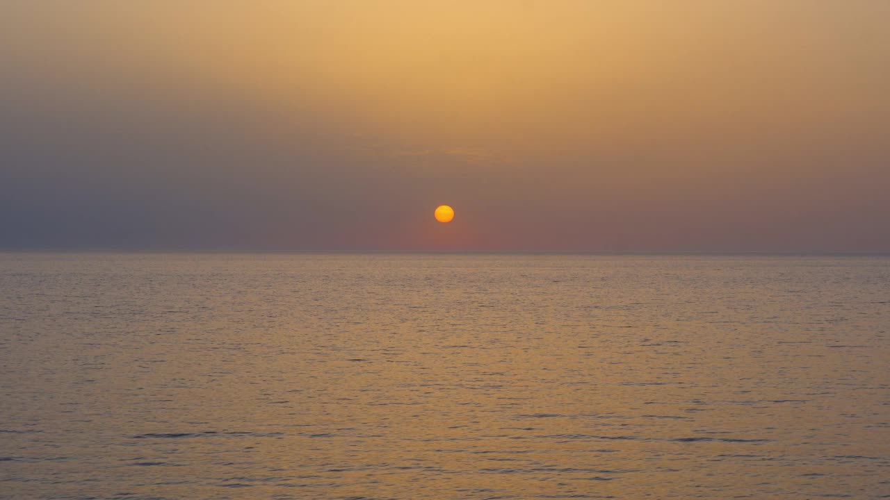 美丽的日落在海上与太阳看起来像一个黄色的圆圈在地平线上的水与日落的颜色和波浪在地中海上视频素材