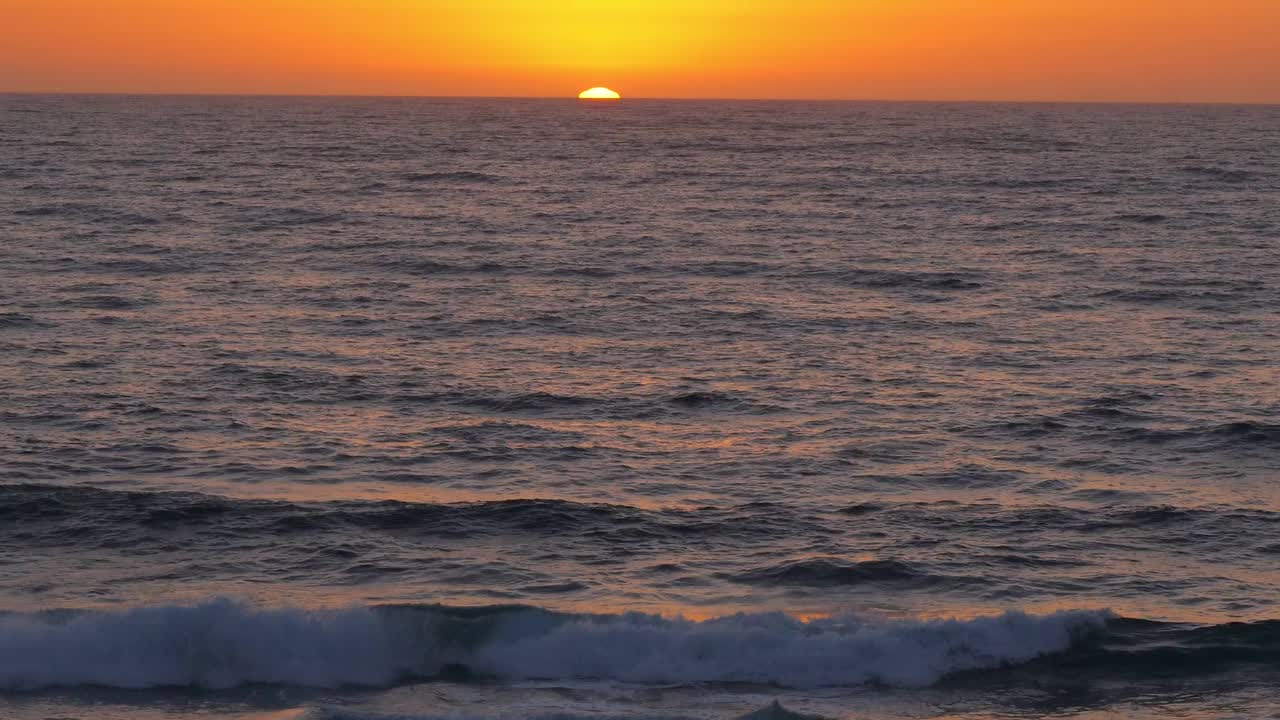 美丽的日落在海上，太阳几乎隐藏在地平线上的水与日落的颜色和波浪在地中海上视频素材