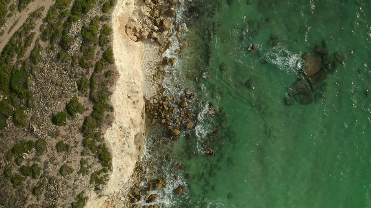 航拍无人机俯视图海浪冲击着有悬崖的荒凉海滩视频素材