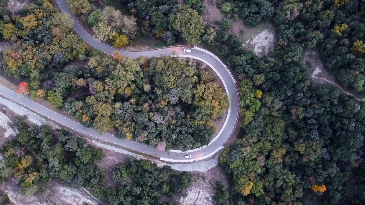 俯瞰航拍的一个发夹弯在欧洲的山路上的汽车行驶视频素材