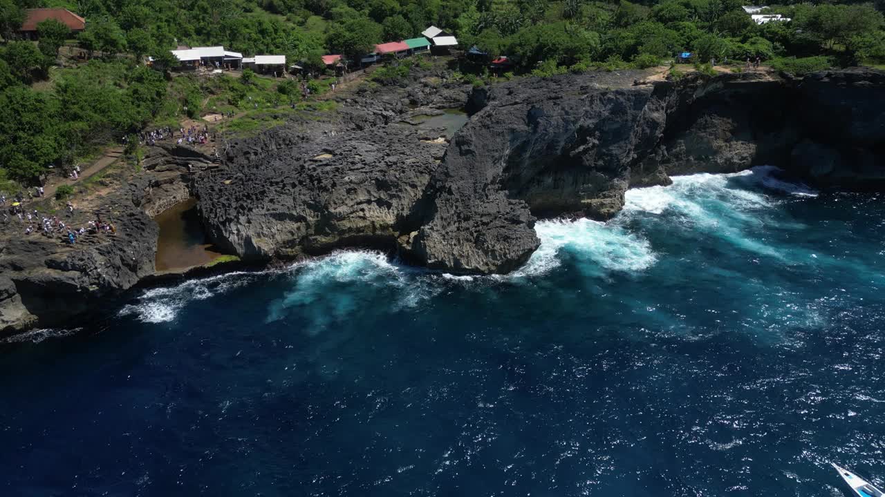 夏天，印尼巴厘岛附近的努沙佩尼达岛，海浪冲击悬崖。视频素材