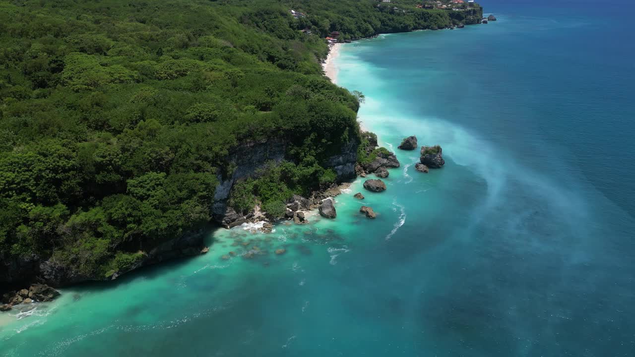 在一个炎热的夏日午后，空中拍摄的印尼巴厘岛海岸蔚蓝的海水。视频素材