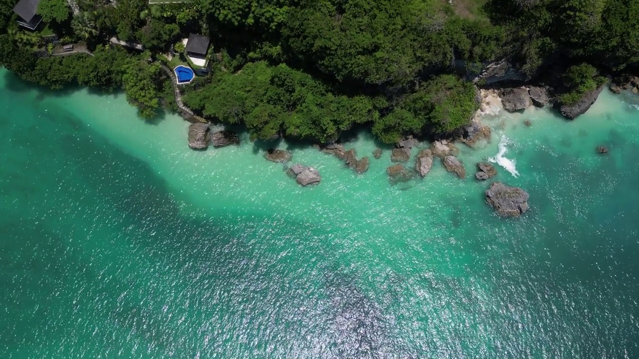 在炎热的夏天，巴厘岛乌鲁瓦图海岸上充满活力的蓝色海景。天线。视频素材