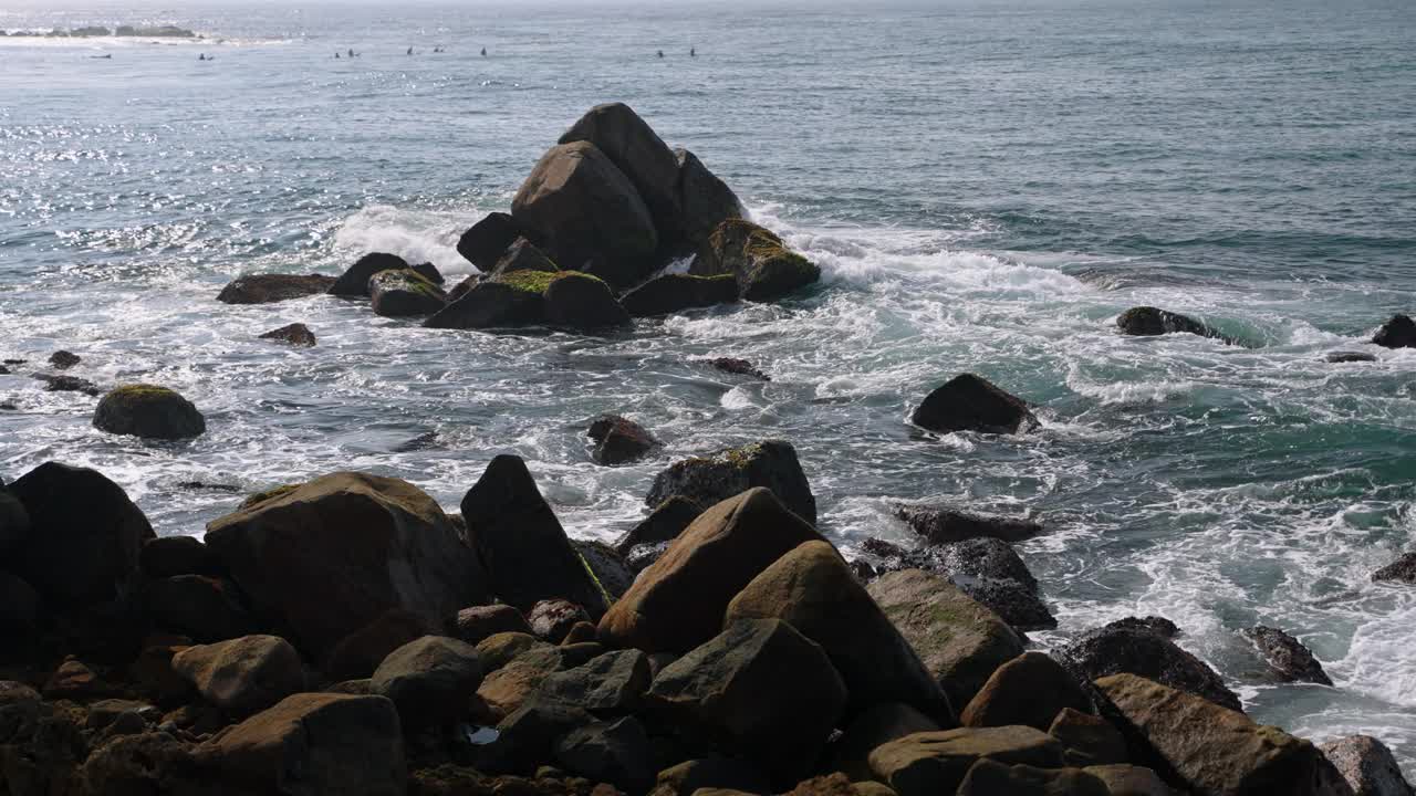 海浪拍打着海岸上长满青苔的岩石。冲浪泡沫在巨石，宁静的海岸景色，自然背景。海景描绘宁静，强大的大海，冥想，正念设置。视频素材