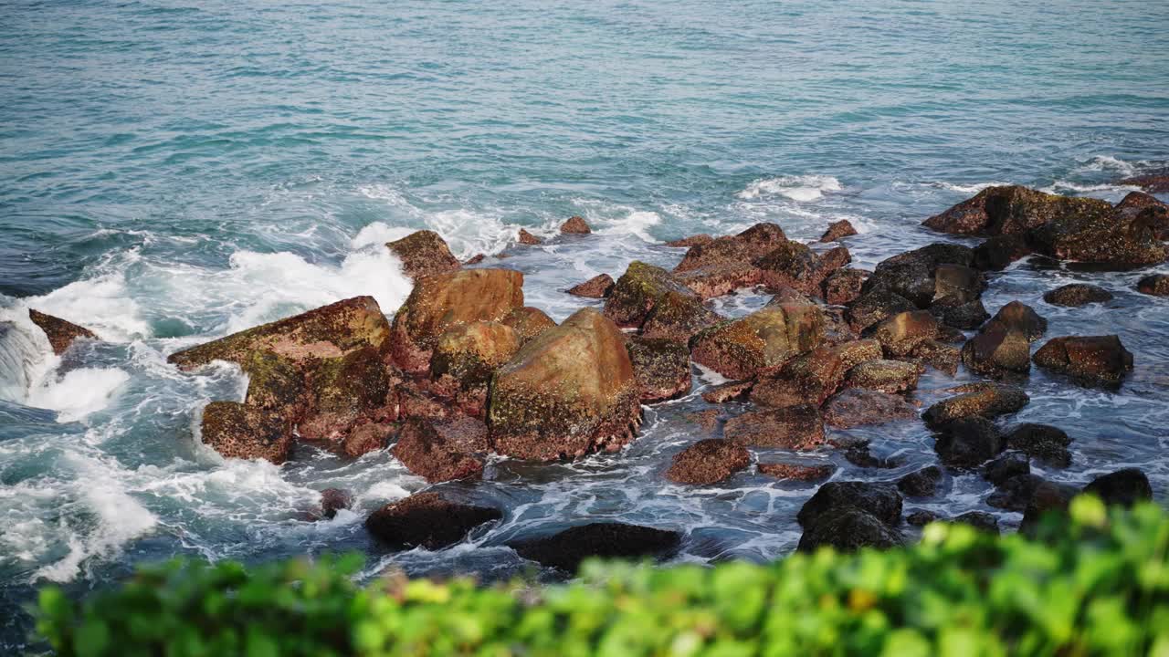 汹涌的海浪吞没了海岸线上崎岖的岩石。海景景描绘了海边大自然的力量。岩石海岸被海浪冲刷，自然风光优美，适合拍摄、气象、生态等项目。视频素材