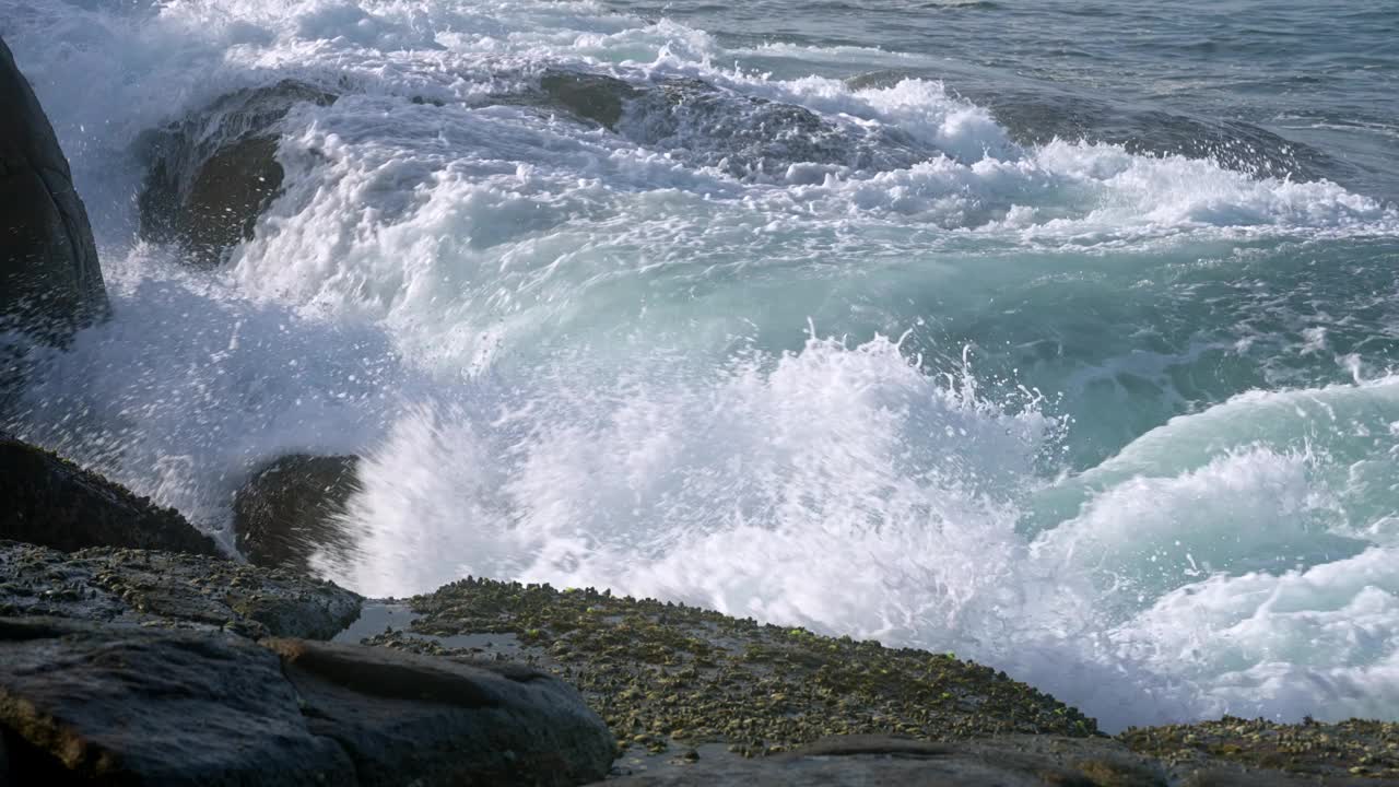 海浪以强大的力量冲击着岩石海岸。浪花、泡沫营造自然风光。沿海景观展示了自然的能量，海边元素的运动。动态波浪作用悬崖。视频素材