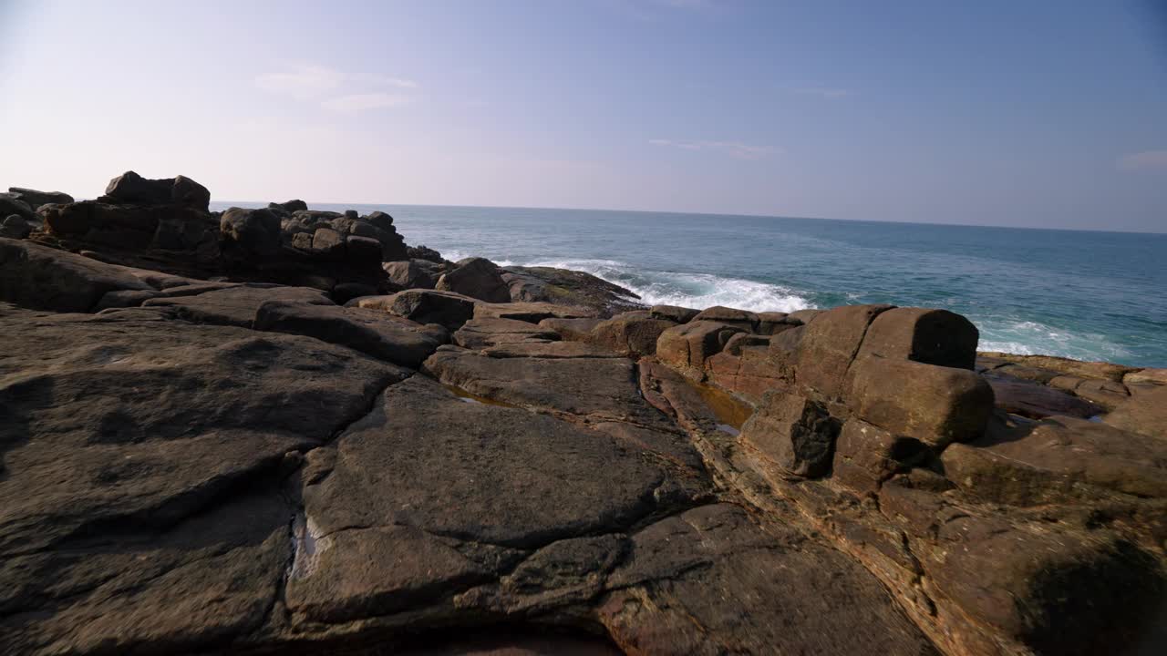 汹涌的海浪冲击着海岸线上崎岖的岩石。海景海景与动态白色泡沫。宁静的海岸景色为自然背景。放松，冥想，自然力量的展示。视频素材