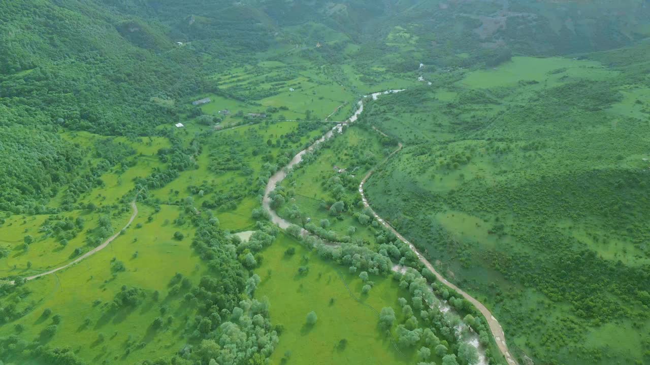 鸟瞰覆盖着绿草和树木的高高的岩石山脉。视频素材