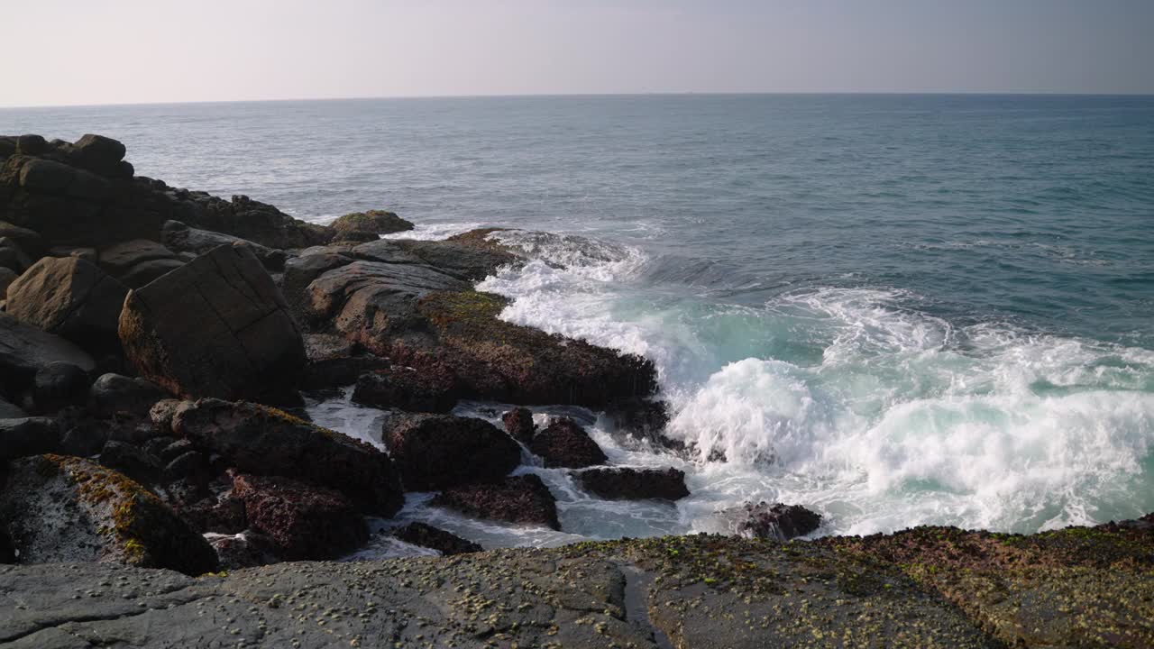 雄伟的海浪冲击着崎岖的海岸巨石，海水在空气中喷射出薄雾，创造了强大的海边奇观。自然爱好者赞叹不已，电影人捕捉原始力量，未受干扰的海洋景观。视频素材